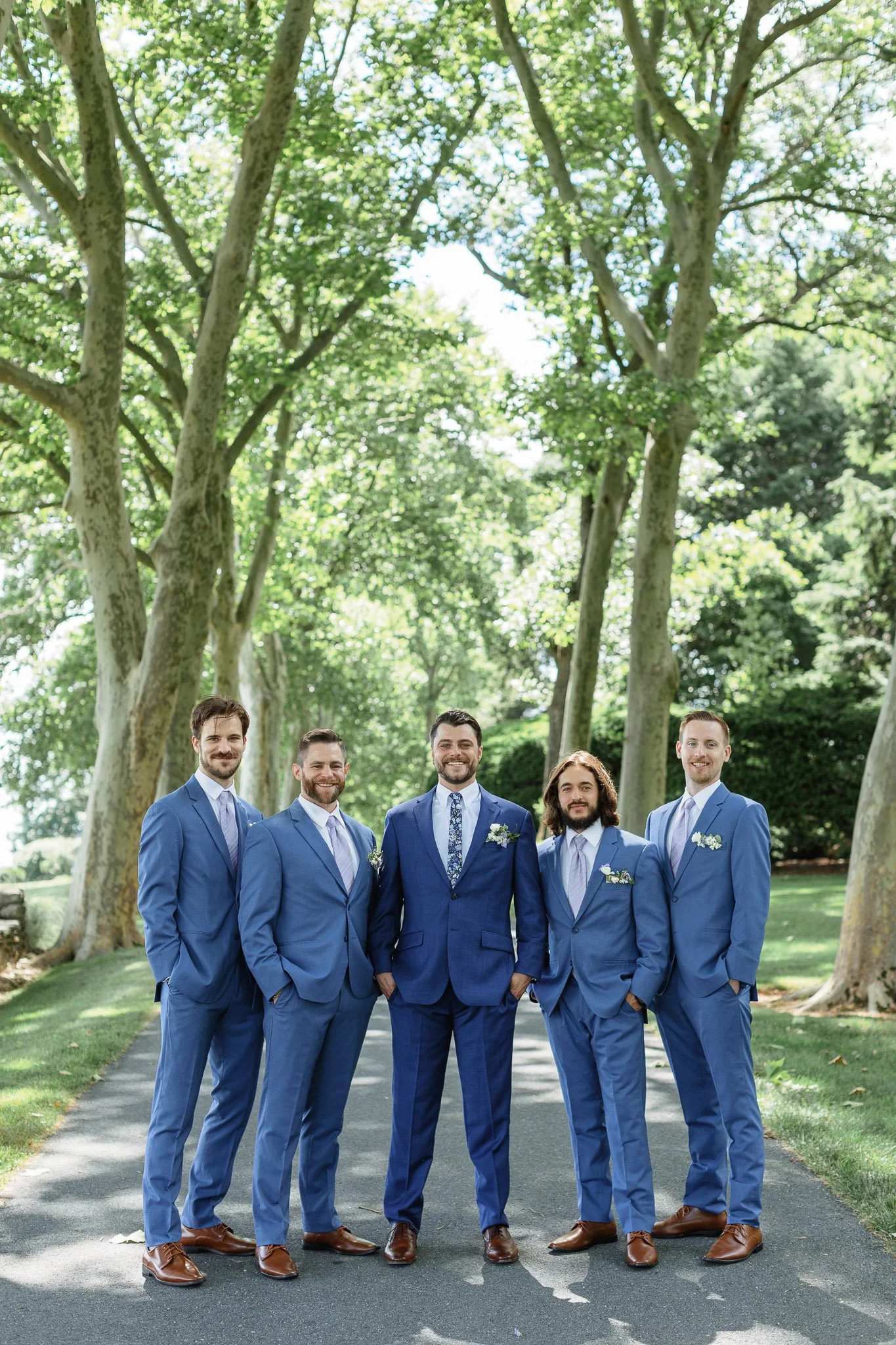 Wedding photo of the groom posing with his groomsmen in matching blue suits