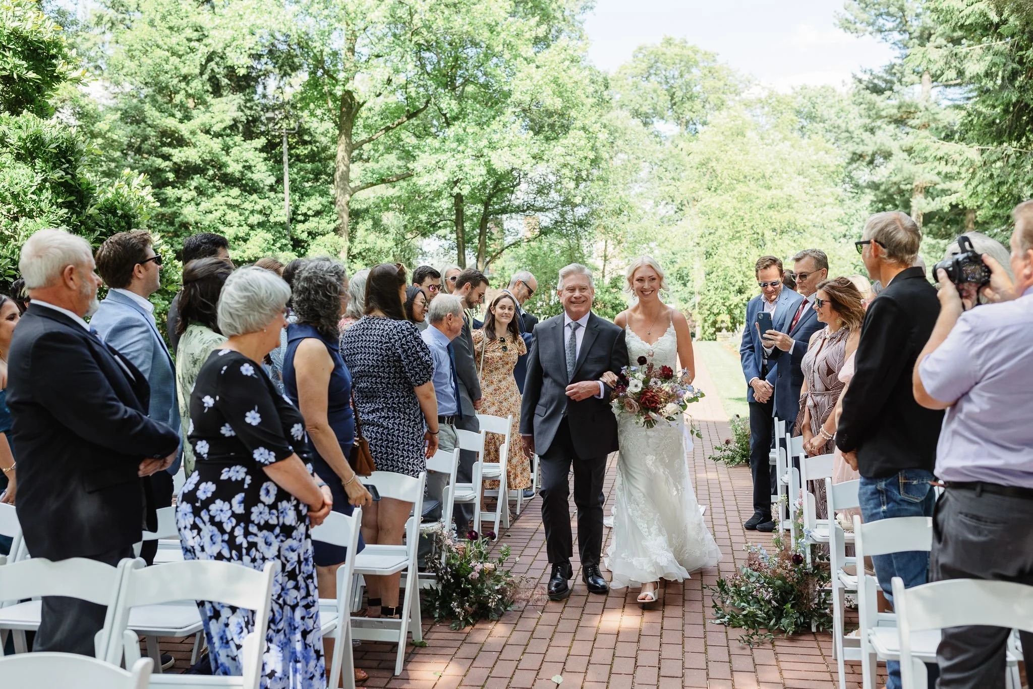 Wide angle shot of the bride walking down the aisle in The Gardens at Drumore Estae