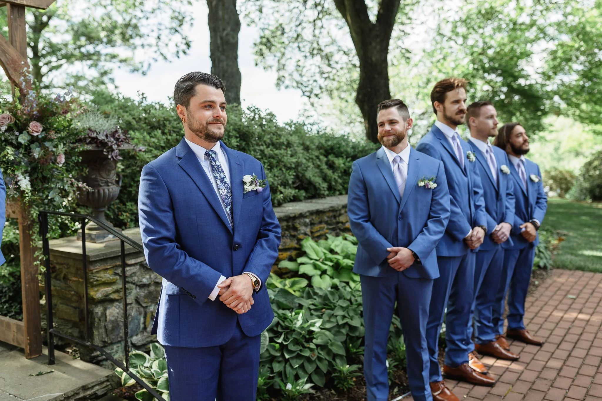 The groom in his blue suit watching the bride approach the altar during their ceremony at Drumore Estate.