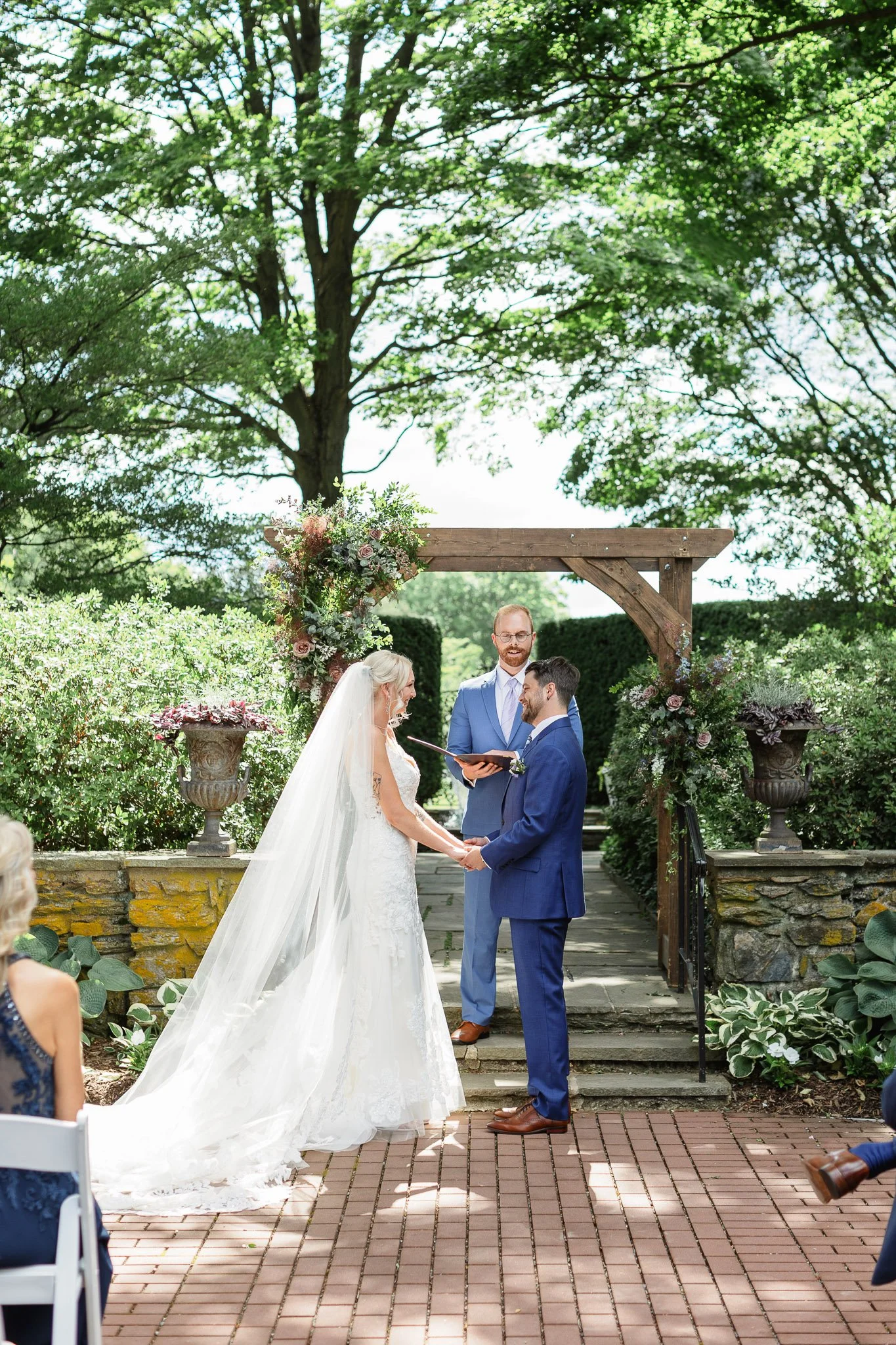 A wedding photo showing the guest's perspective of the couple standing under an arch at Drumore Estate.