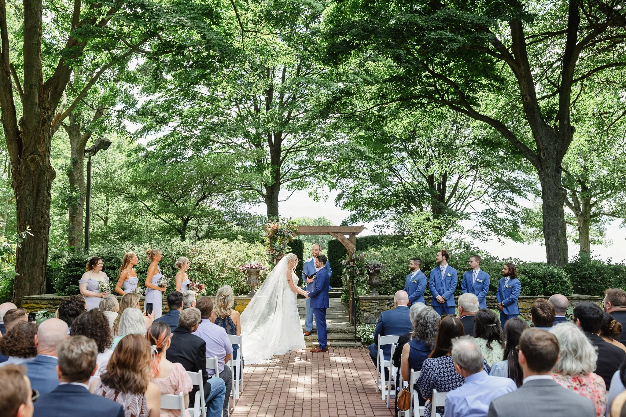 Wide-angle shot of the ceremony site in The Gardens, showing the intimate seating arrangement and decor.