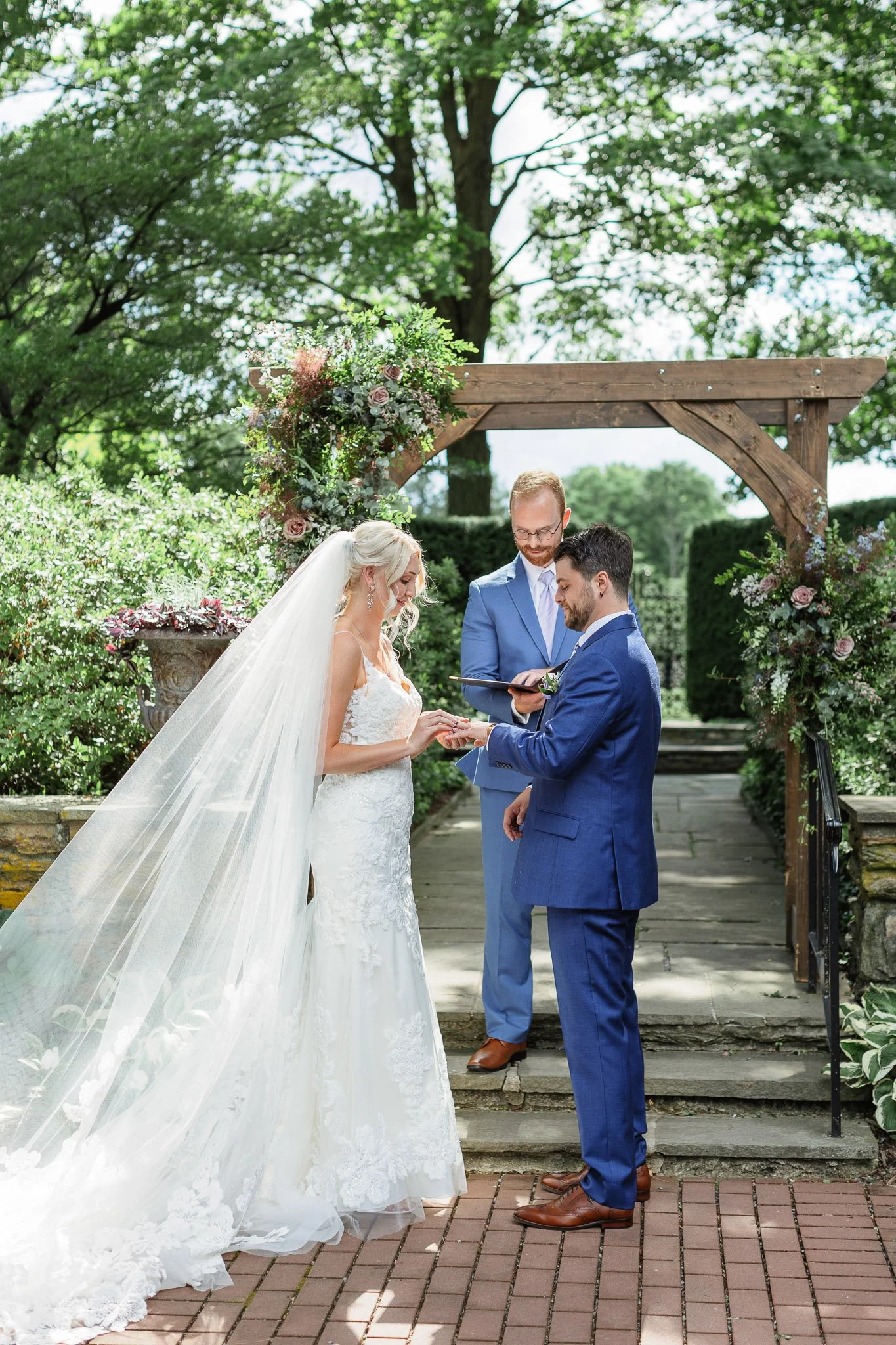 A wedding photographer captures the movement of the bride’s lace veil in the light breeze during the ceremony.