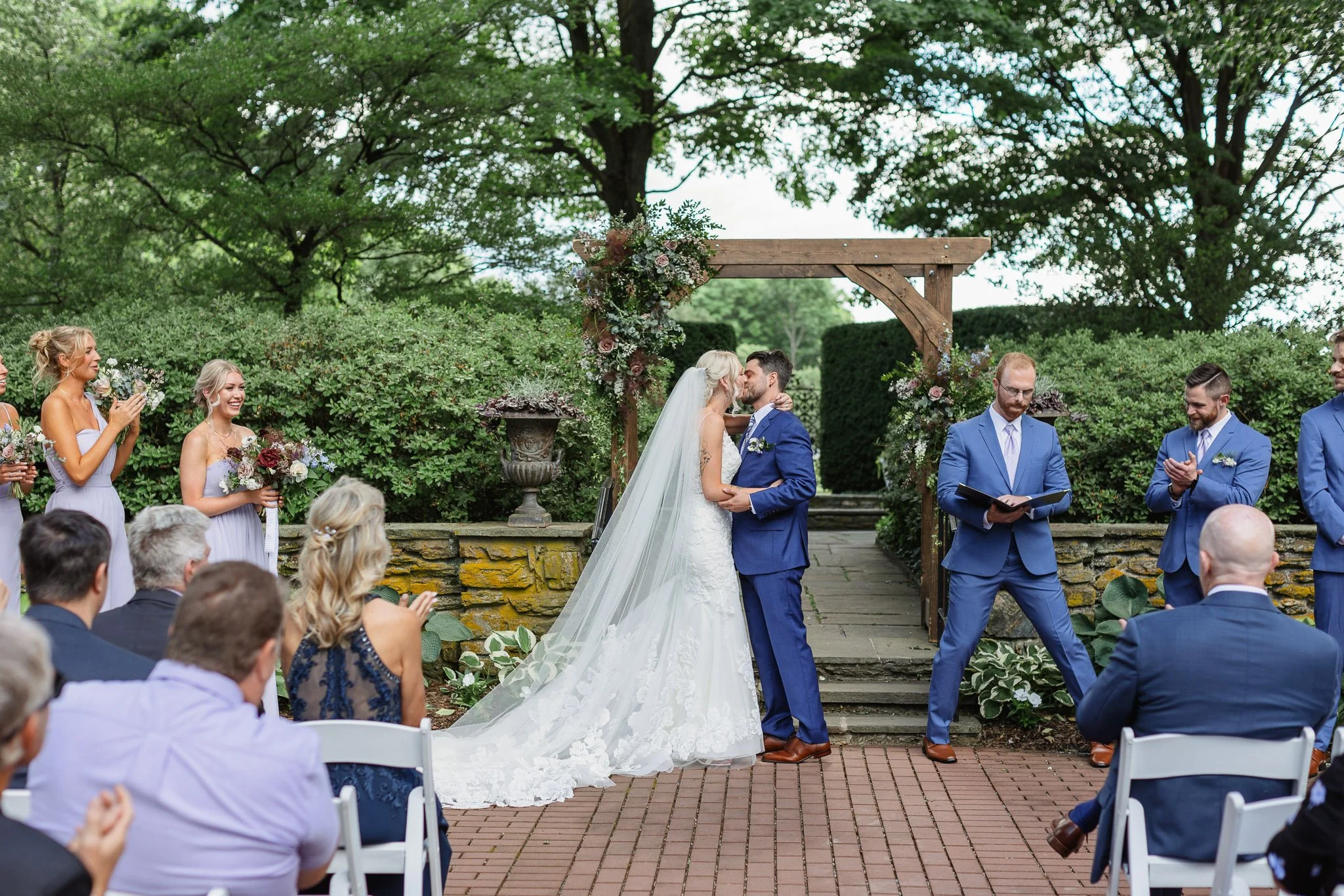 A wedding photographer captures the first kiss during a ceremony at Drumore Estate