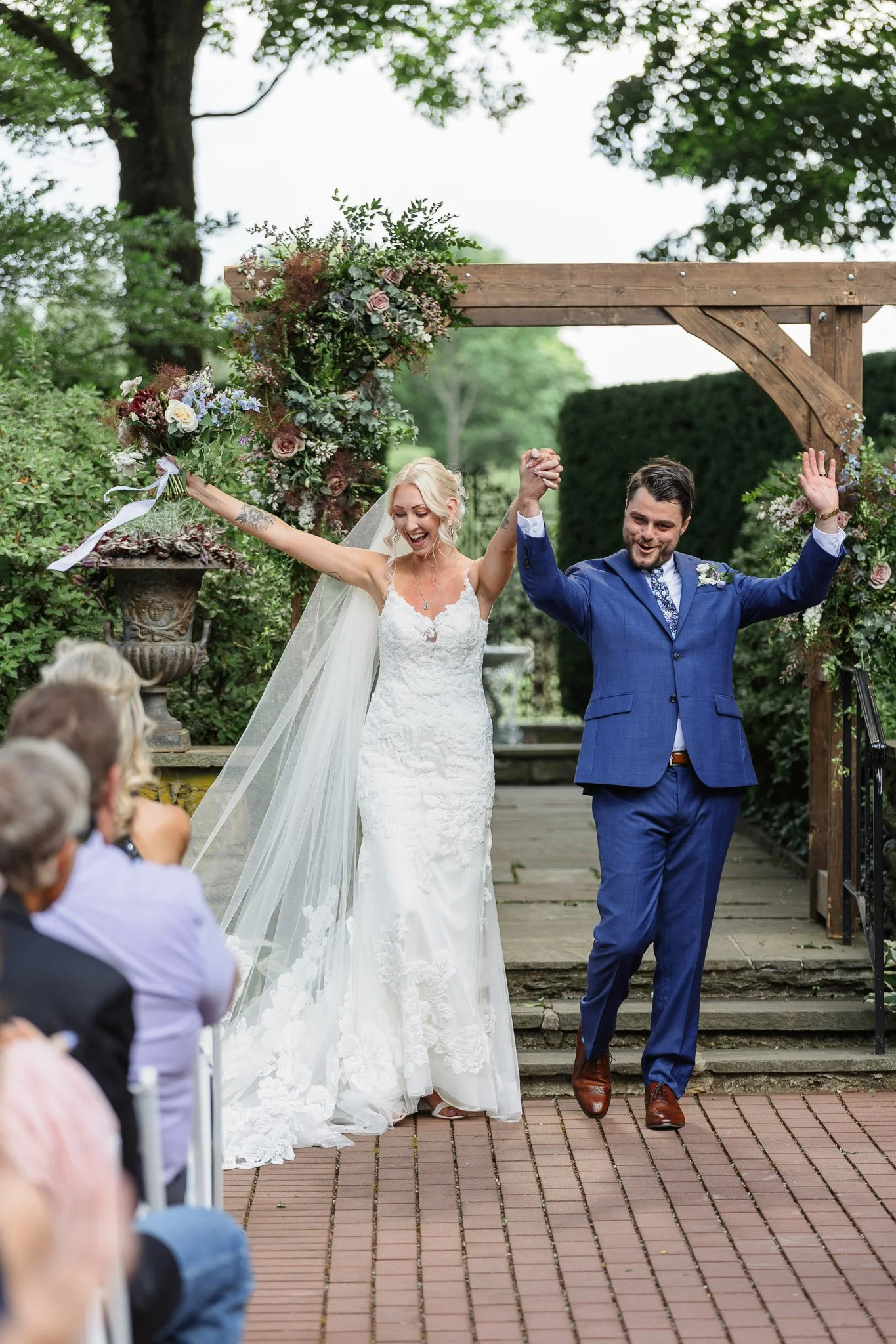 The bride and groom celebrate after exchanging vows in The Gardens at Drumore Estate