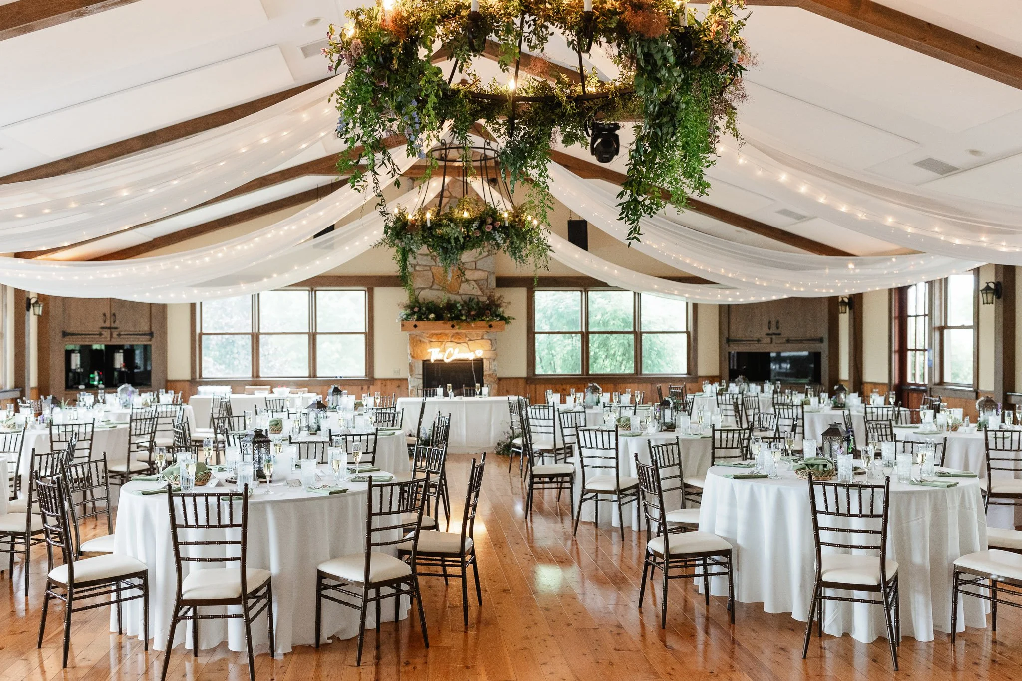 A wide-angle wedding photo of the elegant reception space at Drumore Estate, featuring high ceilings, warm lighting, and beautifully set tables.