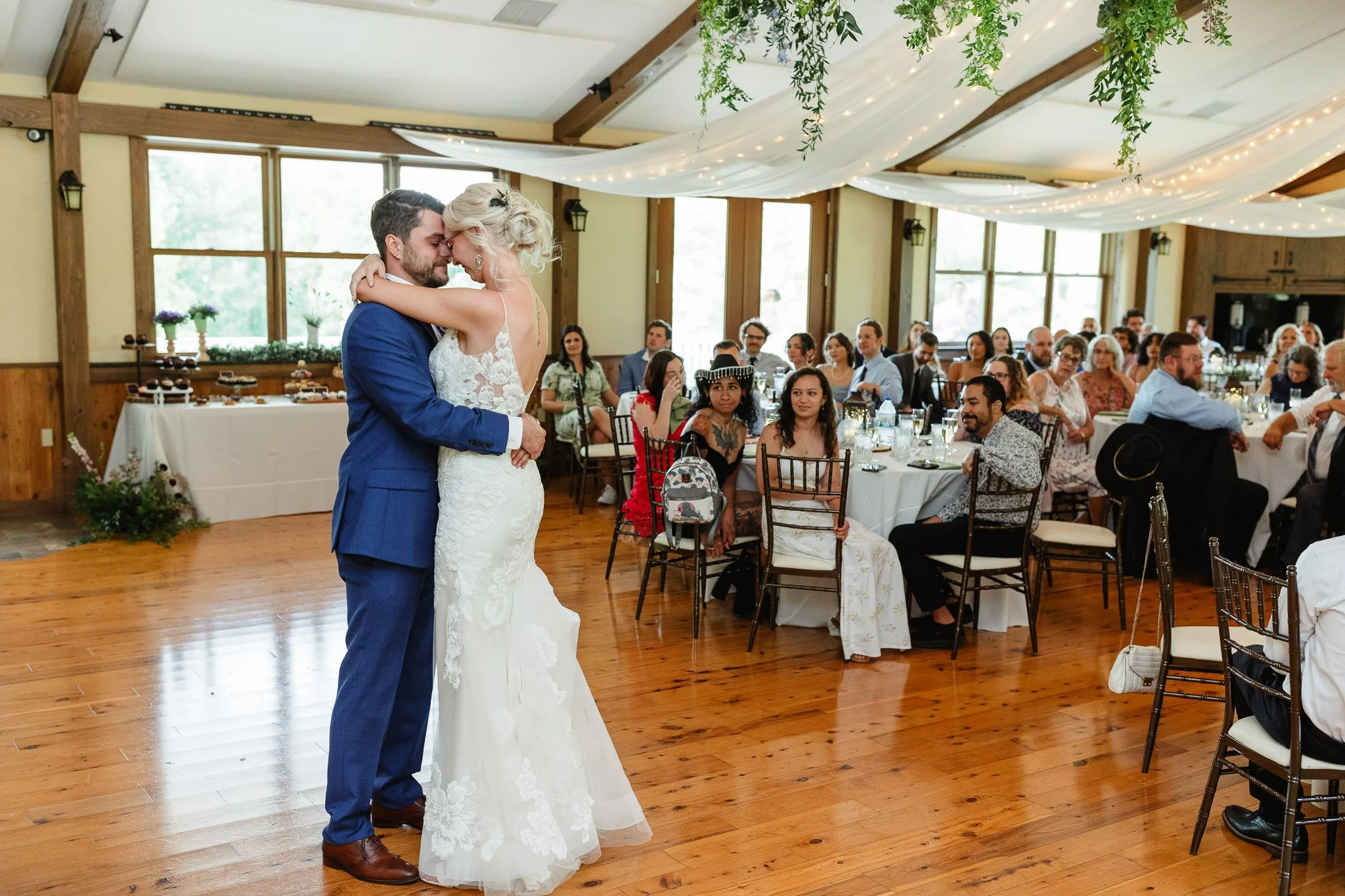 A wedding photographer captures a bride and groom as they share their first dance