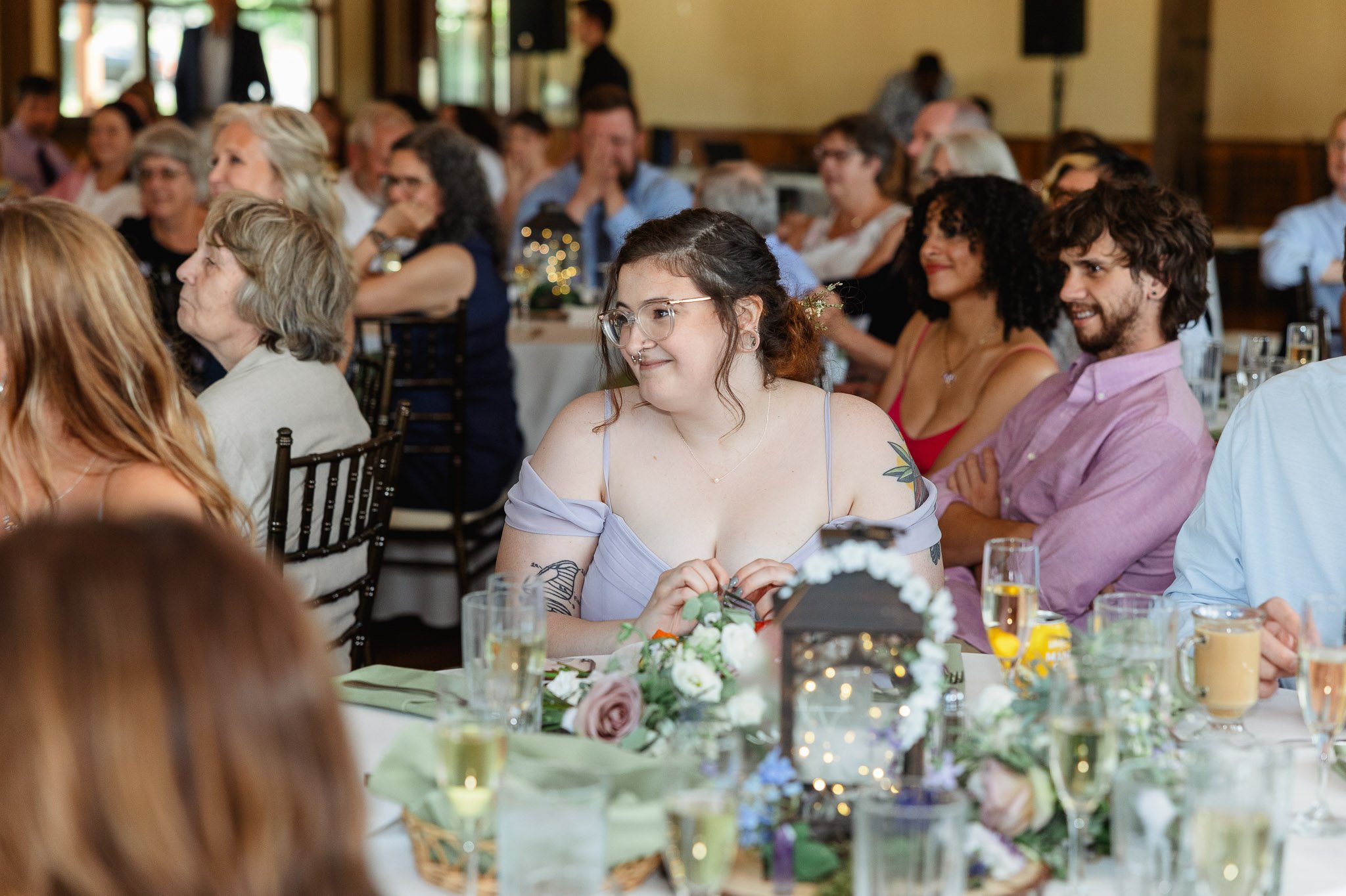 A candid wedding photo of wedding guests listening to the wedding speeches