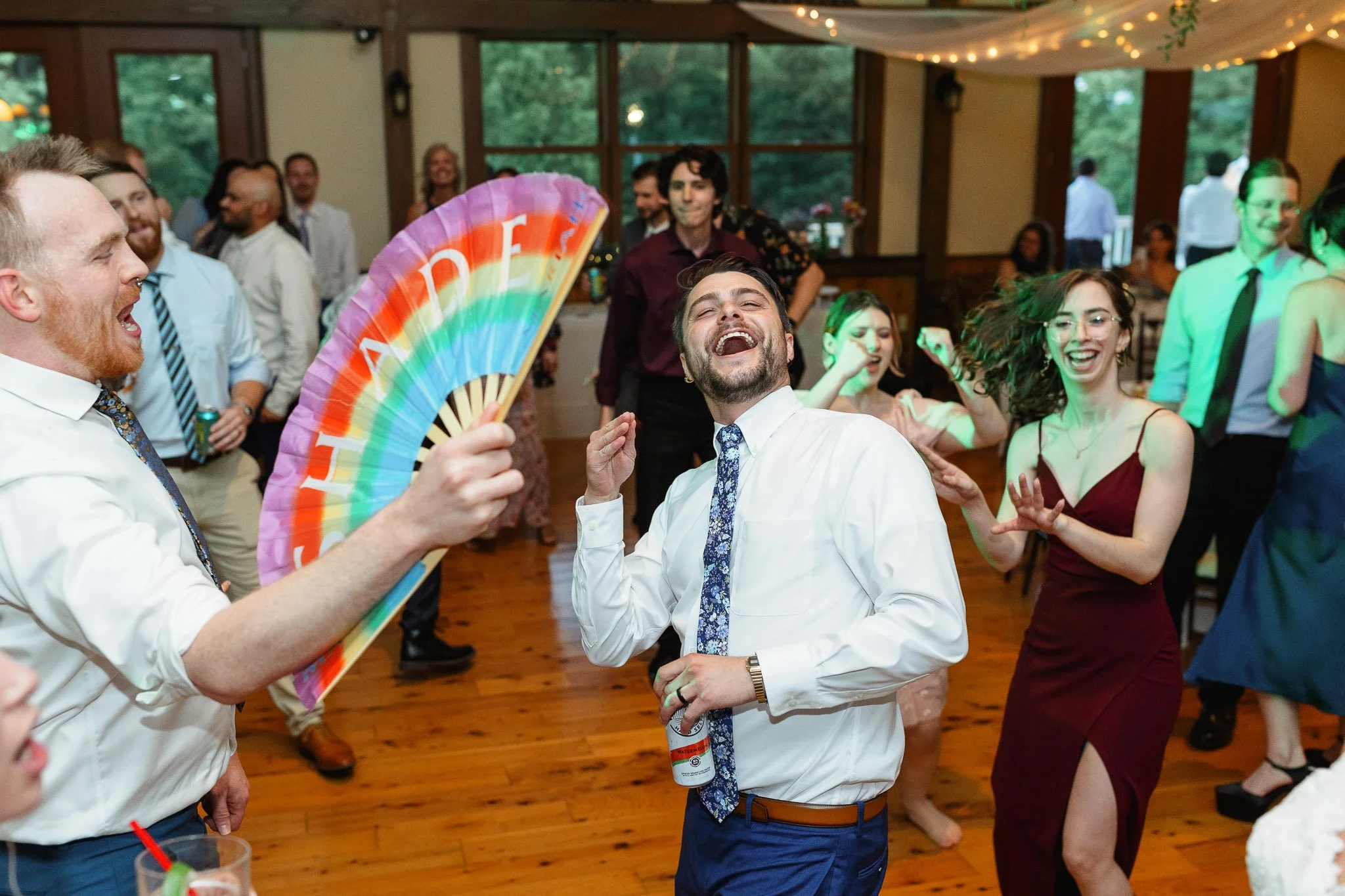 A candid shot of family and friends celebrating on the dance floor during the evening wedding reception.