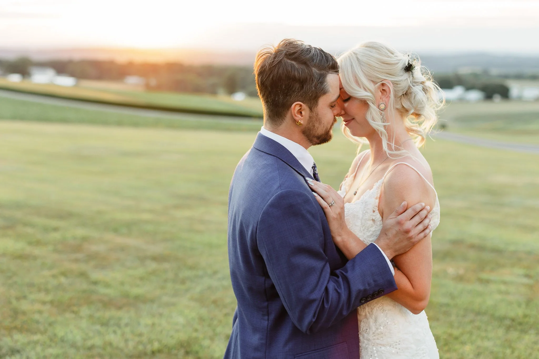 A romantic wedding photo of the bride and groom silhouetted against a vibrant orange and pink sunset at Drumore Estate.
