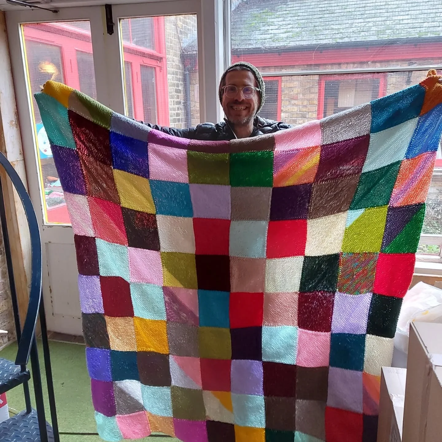 It's been too wet today to do the Knit of the Day shoot outside, so our Director David held up these big blankets for me. They've been sent in by our regular donor Anonymous.  David has been so inspired by seeing all the wonderful things that arrive 