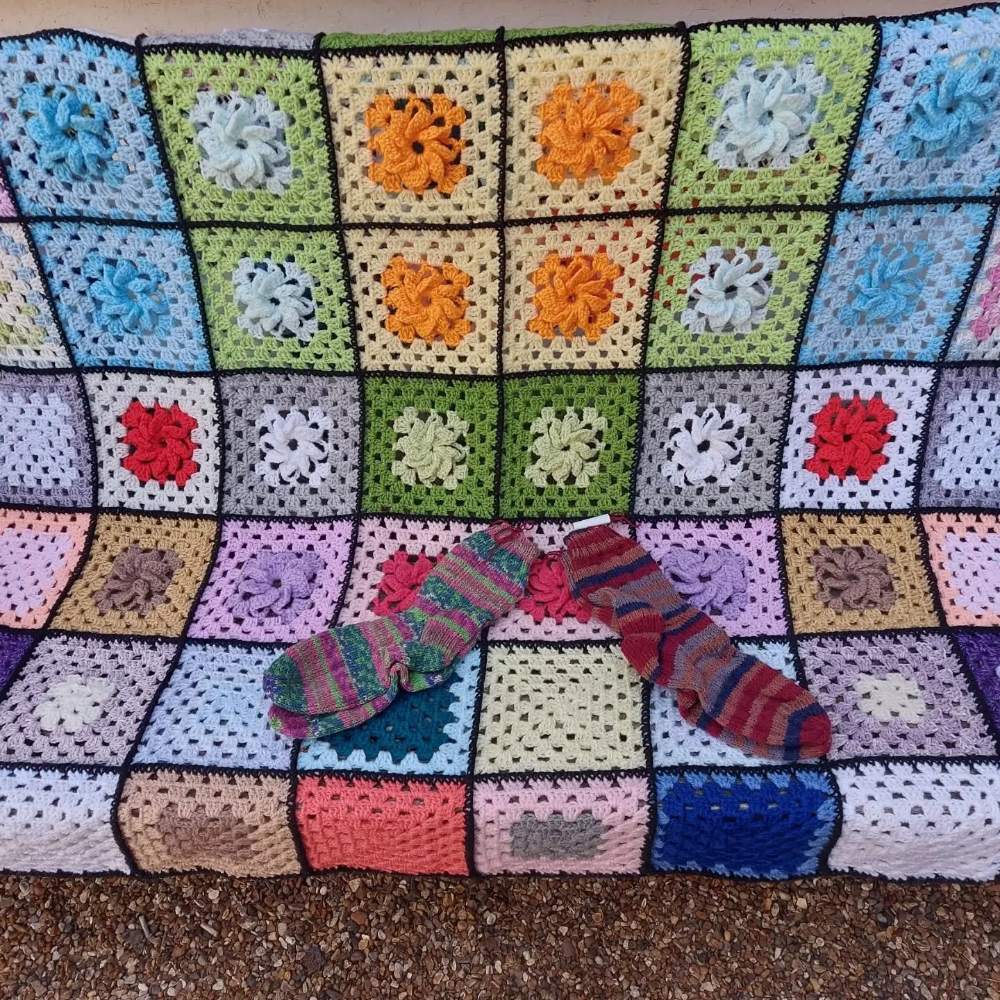 M I in Corby sent us this beautiful blanket in a bundle of other beautiful things. It's a pattern we've not seen before and absolutely love the raised flower motif at the centre of each square. 

Thank you, M I. These are our Knit and Crochet of the 