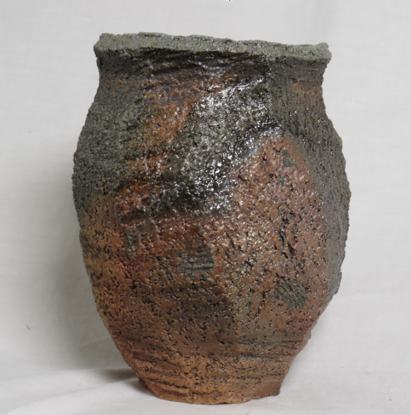 Wood fired, faceted coarse clay vase side fired