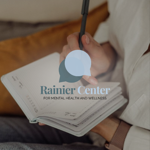 Person holding a pen and a planner or notebook with the Rainier Center logo overlayed.