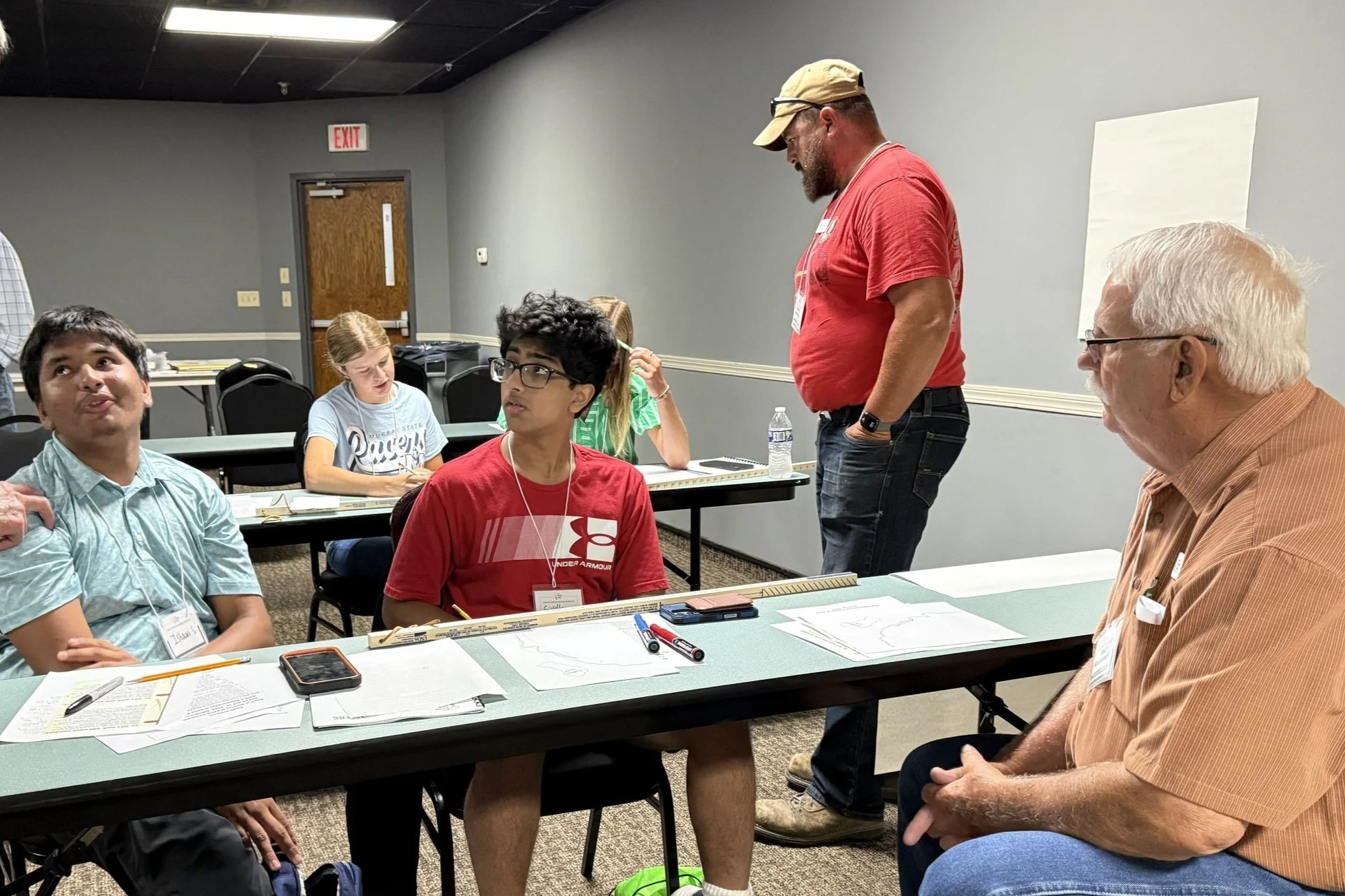 2 young people talking with an adult mentor