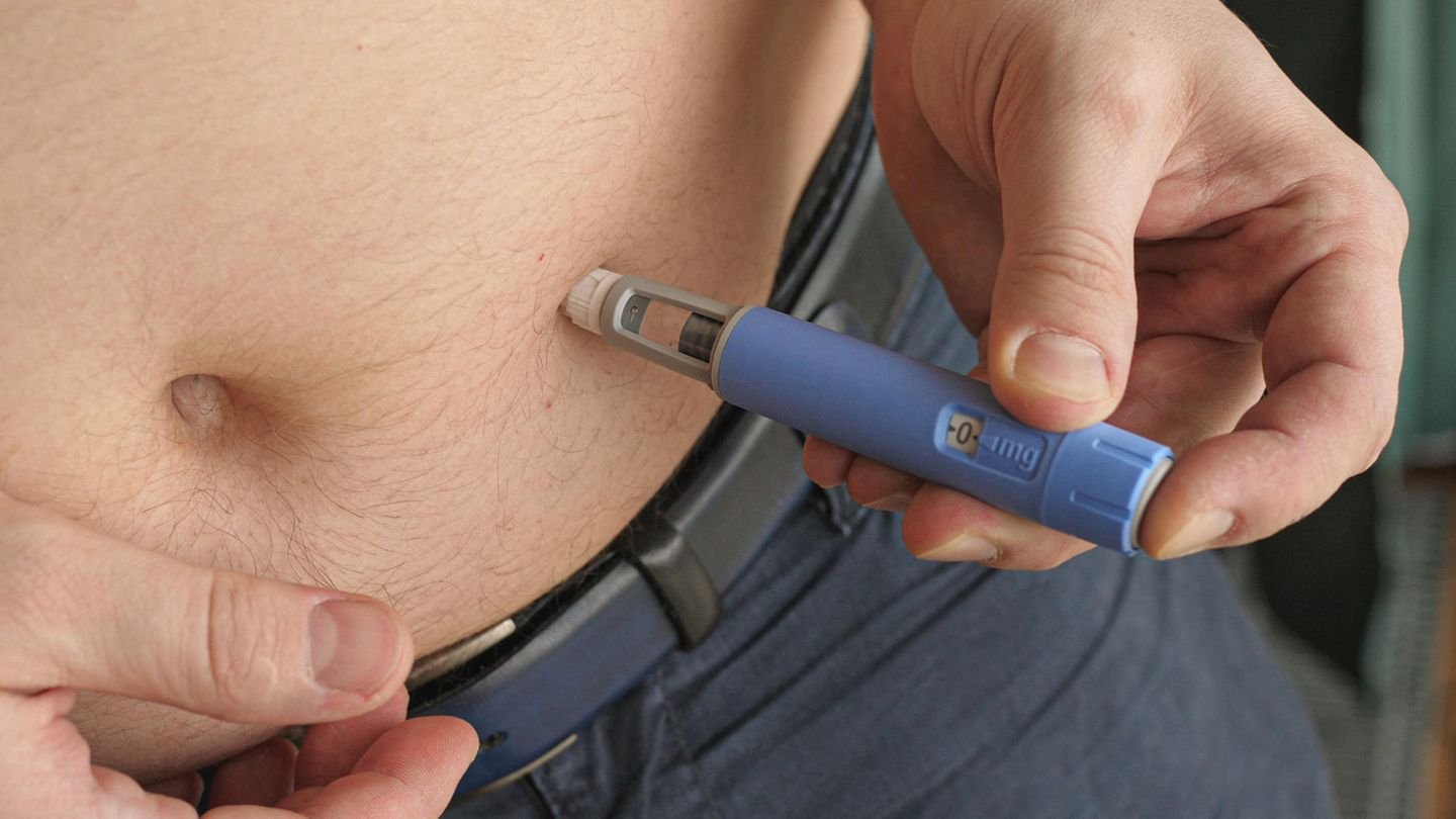 Ein Mann injiziert eine Spritze um Fett zu reduzieren.