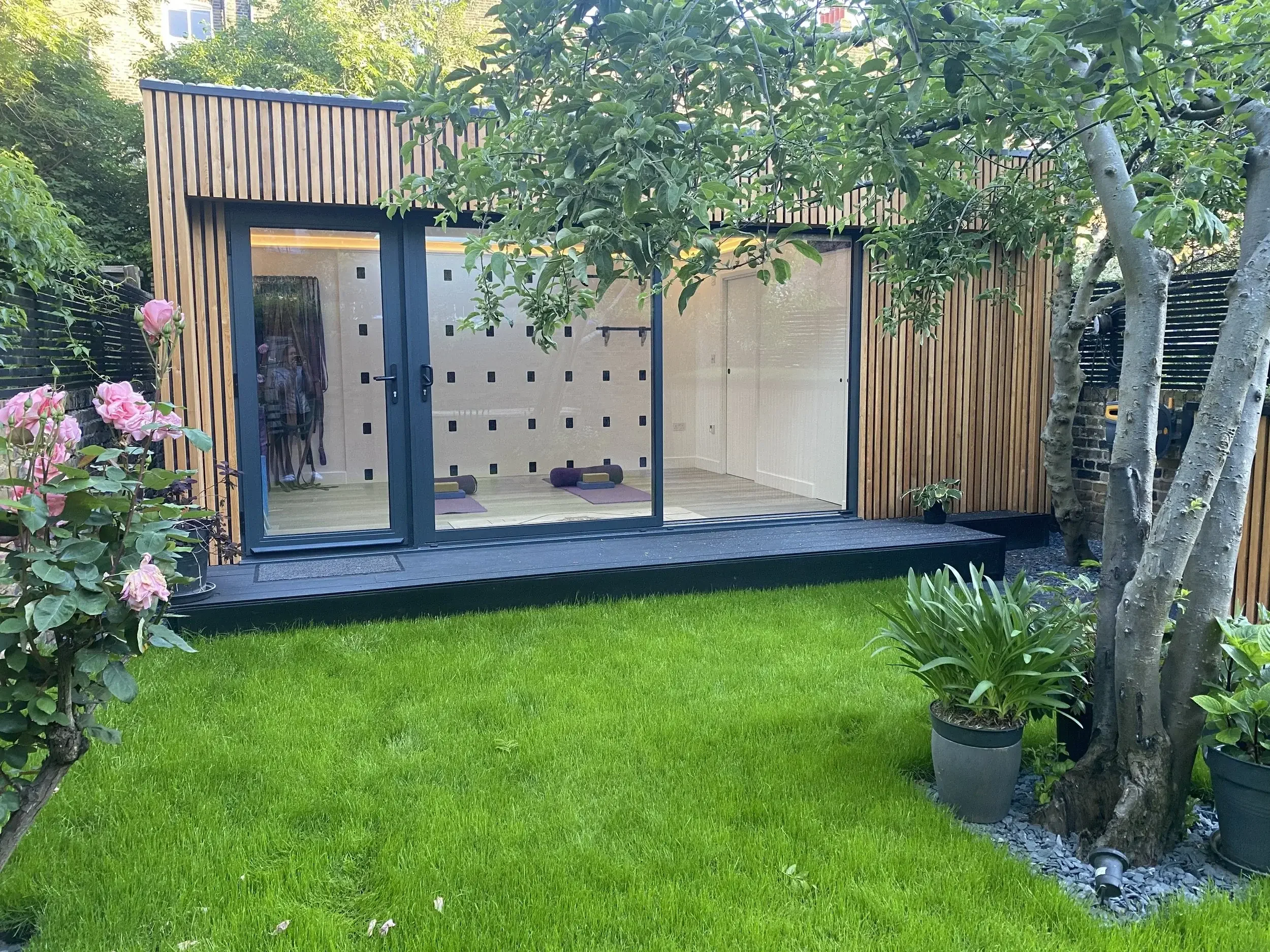 Exterior view of a private yoga studio surrounded by a garden