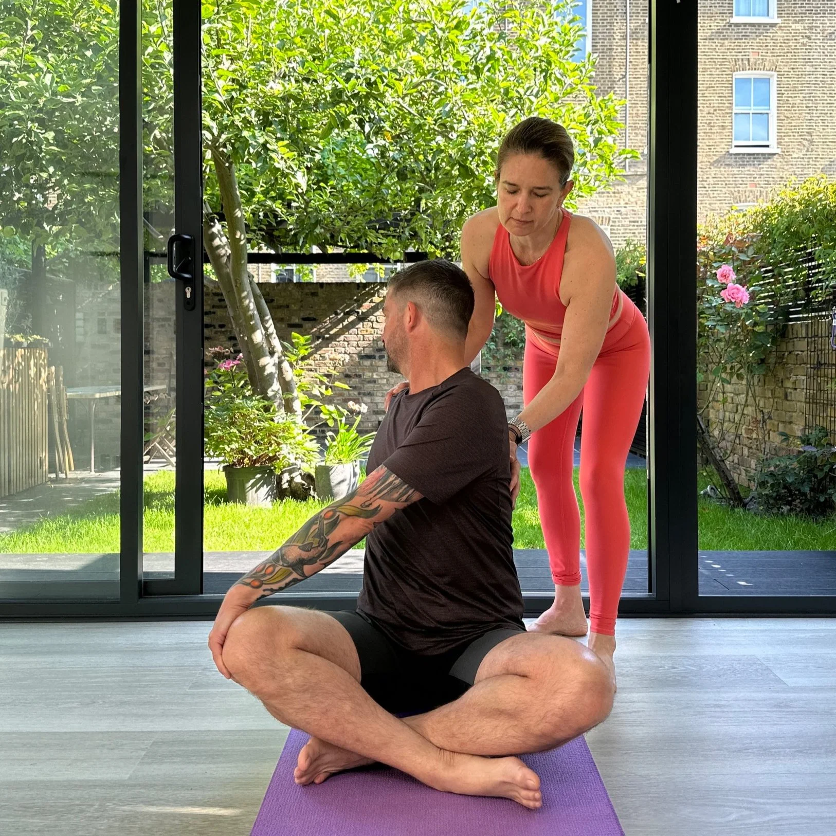 Petra assisting a male client in a yoga therapy private session.