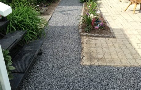 Garden path with Rubberstone next to flower bed and stairs