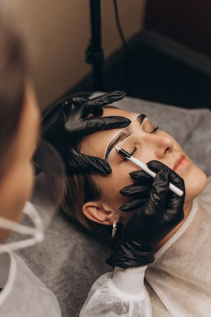 Eine Frau erhält eine Augenbrauen-Mikropigmentierung oder -Pigmentierung durch einen Fachmann.