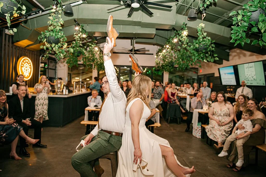 Wedding couple holding up shoes at a brewery wedding in Charlotte, NC