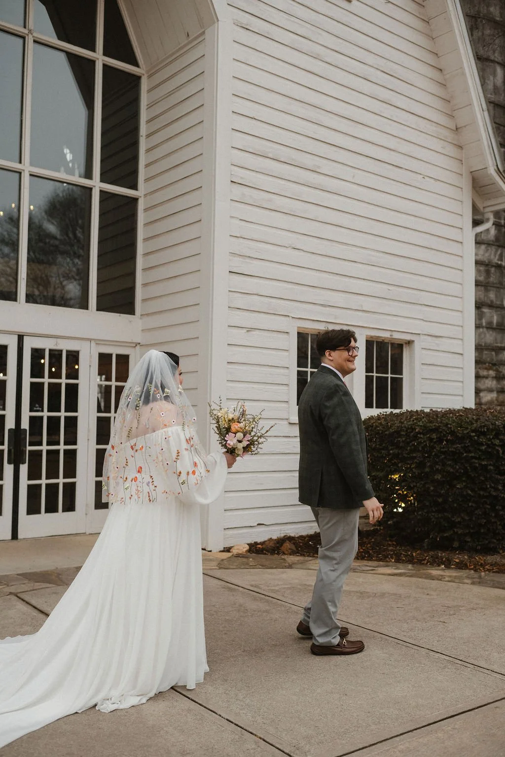 Bride walks toward groom outside the chapel at Anne Springs Close Greenway Events — coordinated by Charlotte Wedding Coordinator.