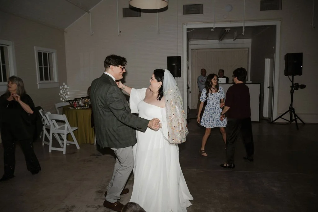 Bride and groom dance joyfully together as guests join in the celebration on the dance floor — coordinated by Charlotte Wedding Coordinator