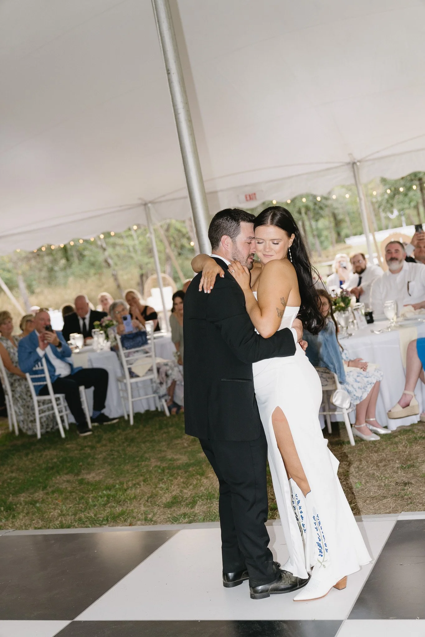 Bride and groom dancing under a tent at their tented wedding, planned by a Charlotte wedding planner