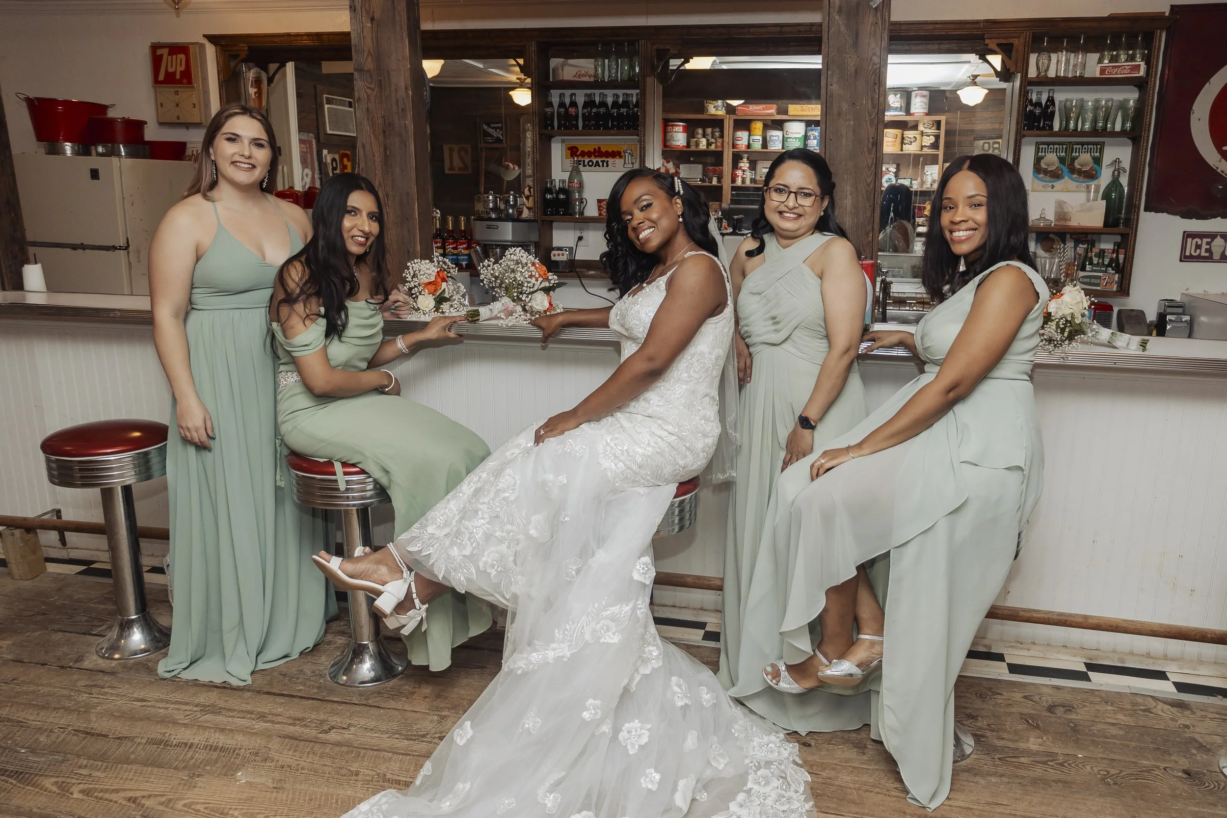 Bride sitting with bridesmaids at the bar station during the wedding reception.