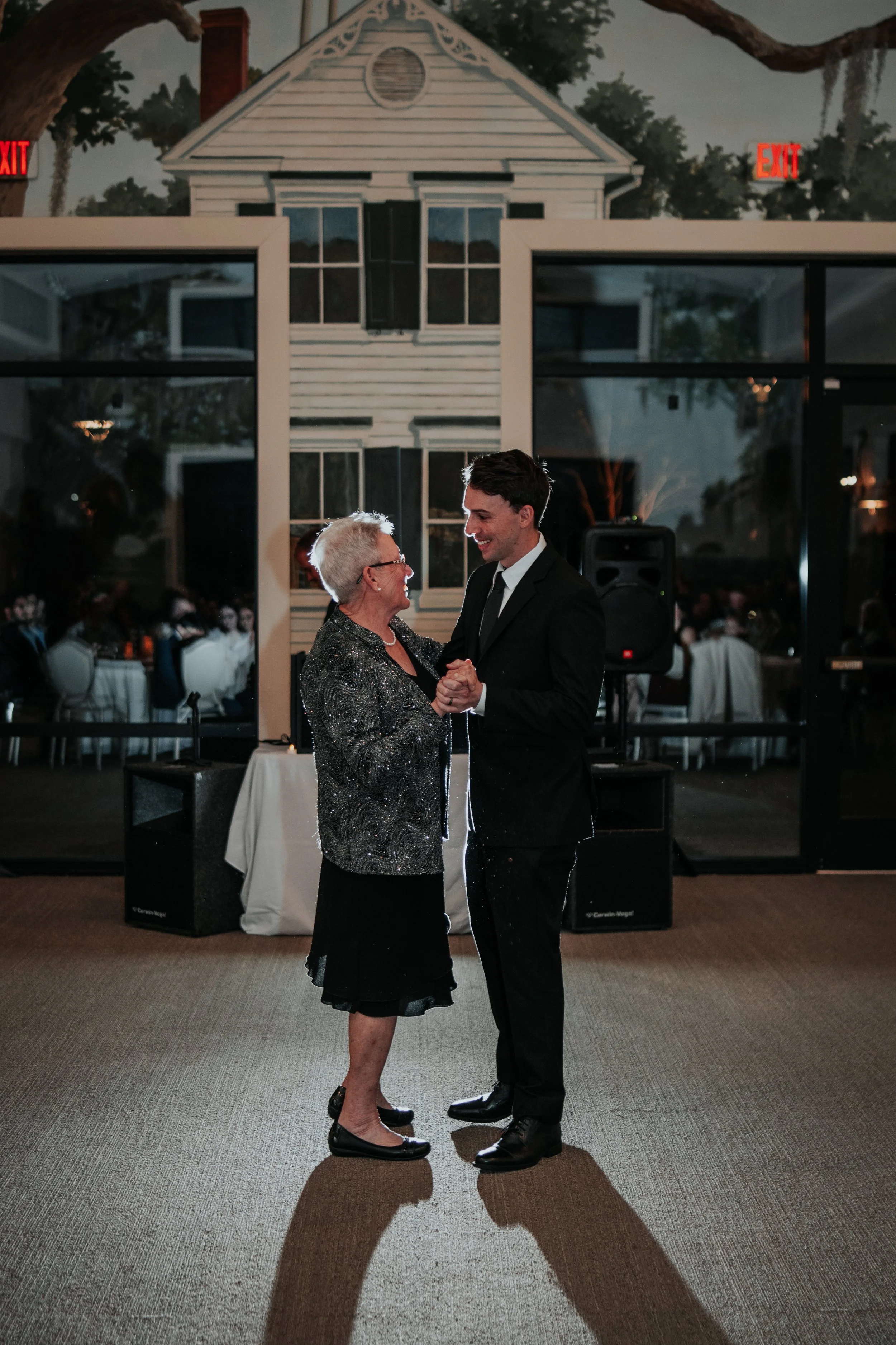 Groom shares a heartfelt dance with his mother during the reception, surrounded by guests and warm evening light — planned by Charlotte Wedding Planner at Lowcountry Park Venues.