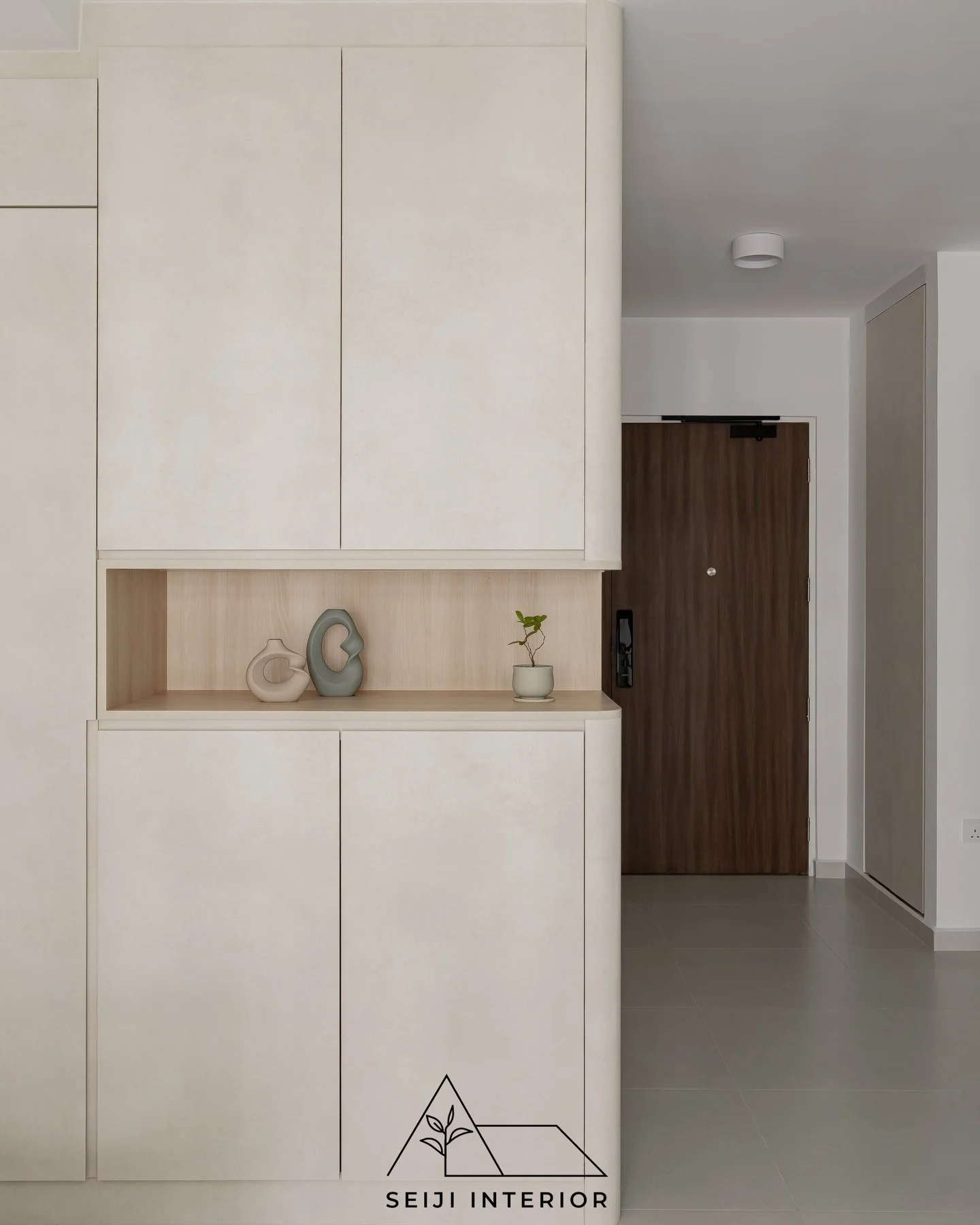 For this minimalist project, we designed an entryway that sets a calm tone the moment you step inside.

Seamless floor-to-ceiling cabinetry hides the daily clutter, while a warm, curved wood niche creates the perfect spot for your favorite essentials
