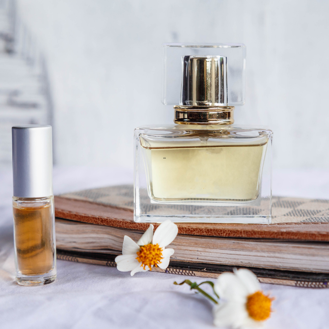 Perfume bottle and perfume oil roll-on with white flowers for fragrance and personal scent.