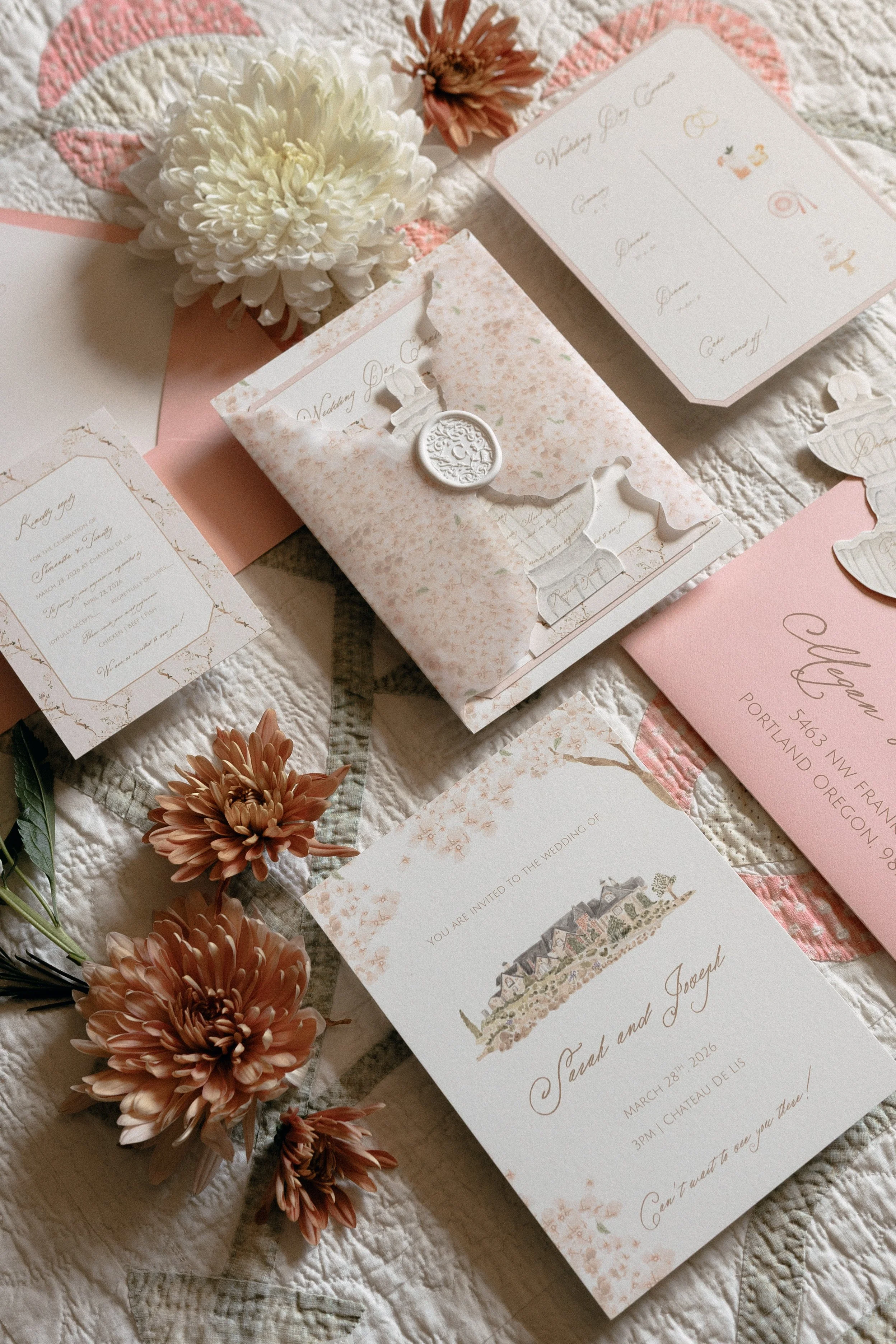 Wedding invitations and floral decorations on a quilted surface, with pink and white color themes.