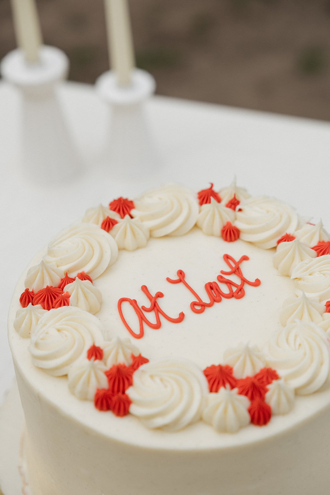 A white cake decorated with cream swirls and red and white piped frosting, with the message 'Act Respect' written in red icing on top.