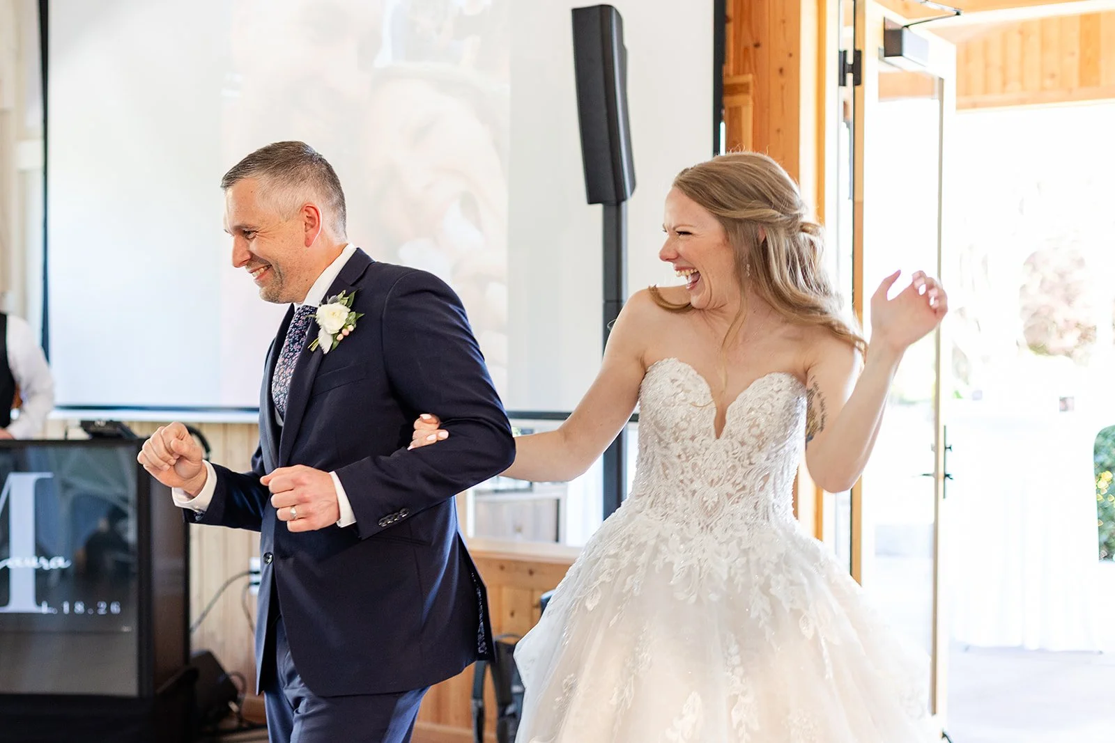 A bride and groom dancing happily at their wedding reception.