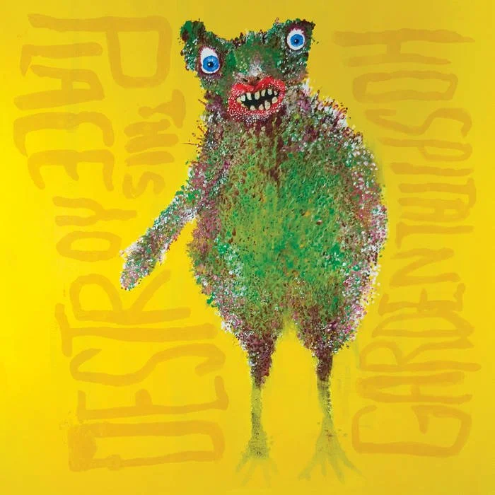 Colorful, abstract illustration of a fuzzy creature with big blue eyes, wide mouth showing teeth, and bird-like feet on a yellow background with partially obscured text.