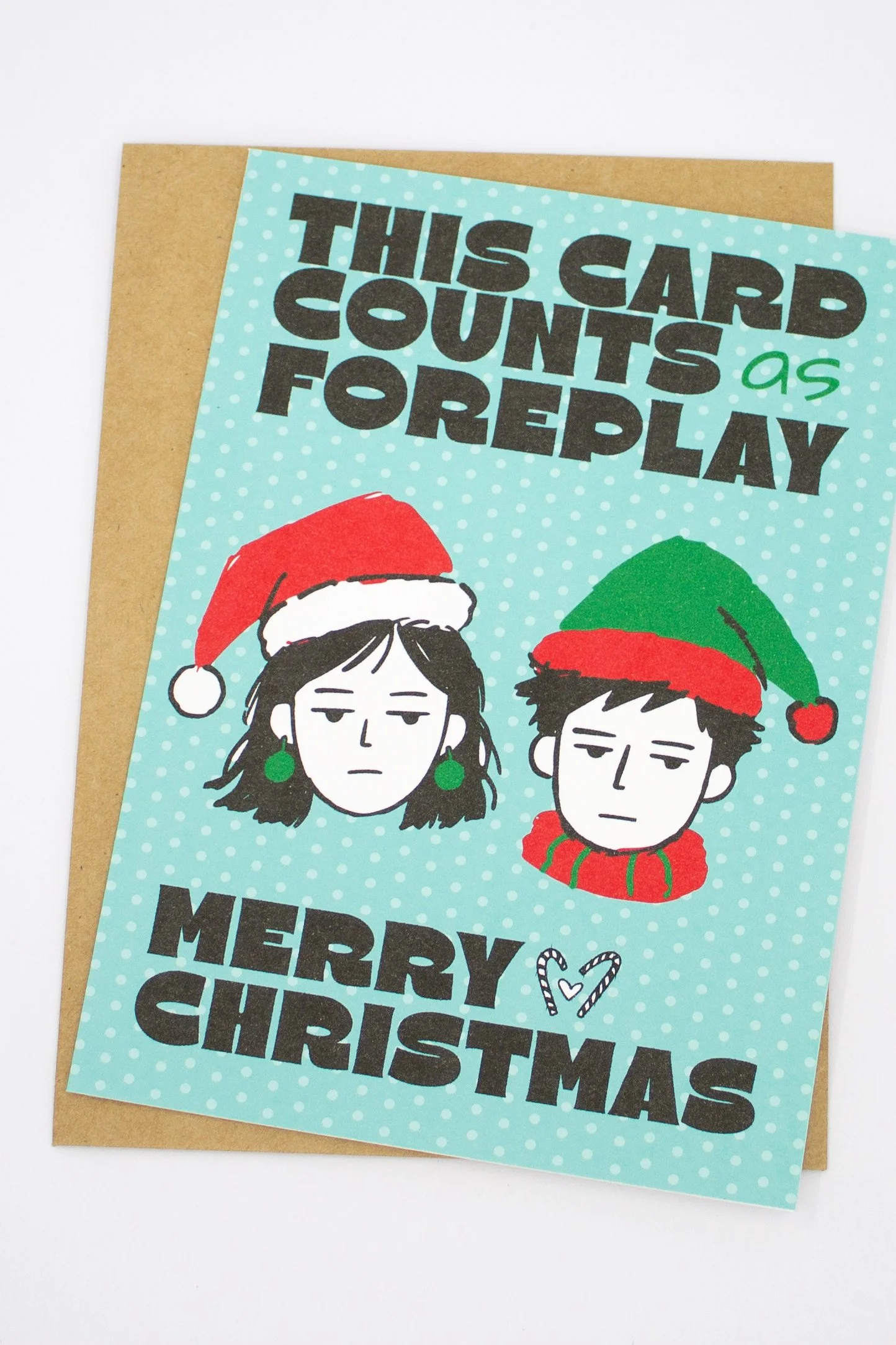 Funny Christmas greeting card featuring illustrated man and woman wearing Santa hats with the saying "This card counts as foreplay."