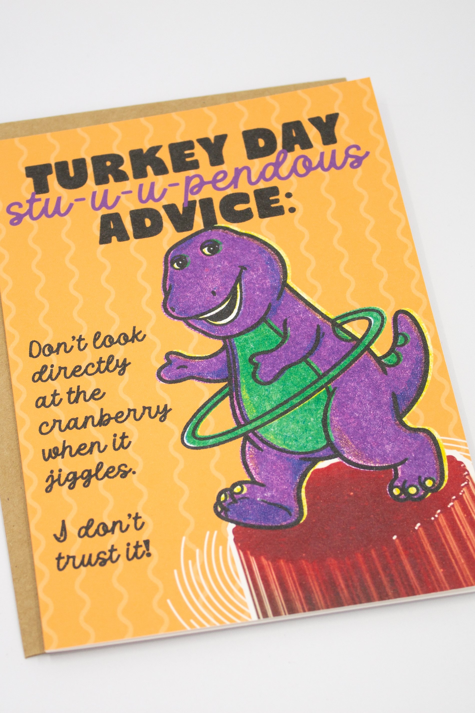 This Thanksgiving card for friends, siblings, coworkers, or fellow 90s survivors, features features Barney the purple dinosaur hula-hooping on top of canned cranberry jelly