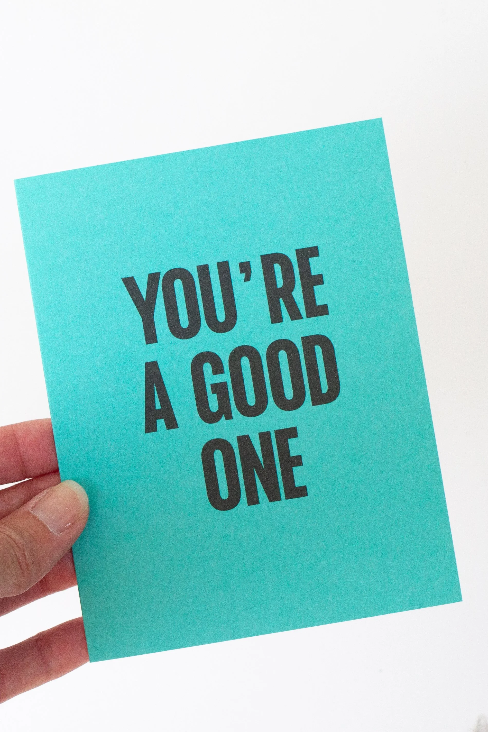 The front of this turquoise card is a text-only phrase: “You’re a Good One.”