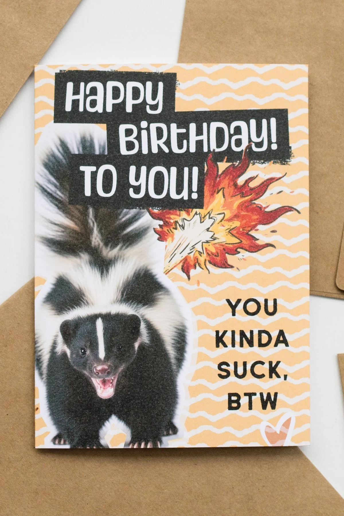 Yellow-orange birthday card with angry skunk. Blank inside.