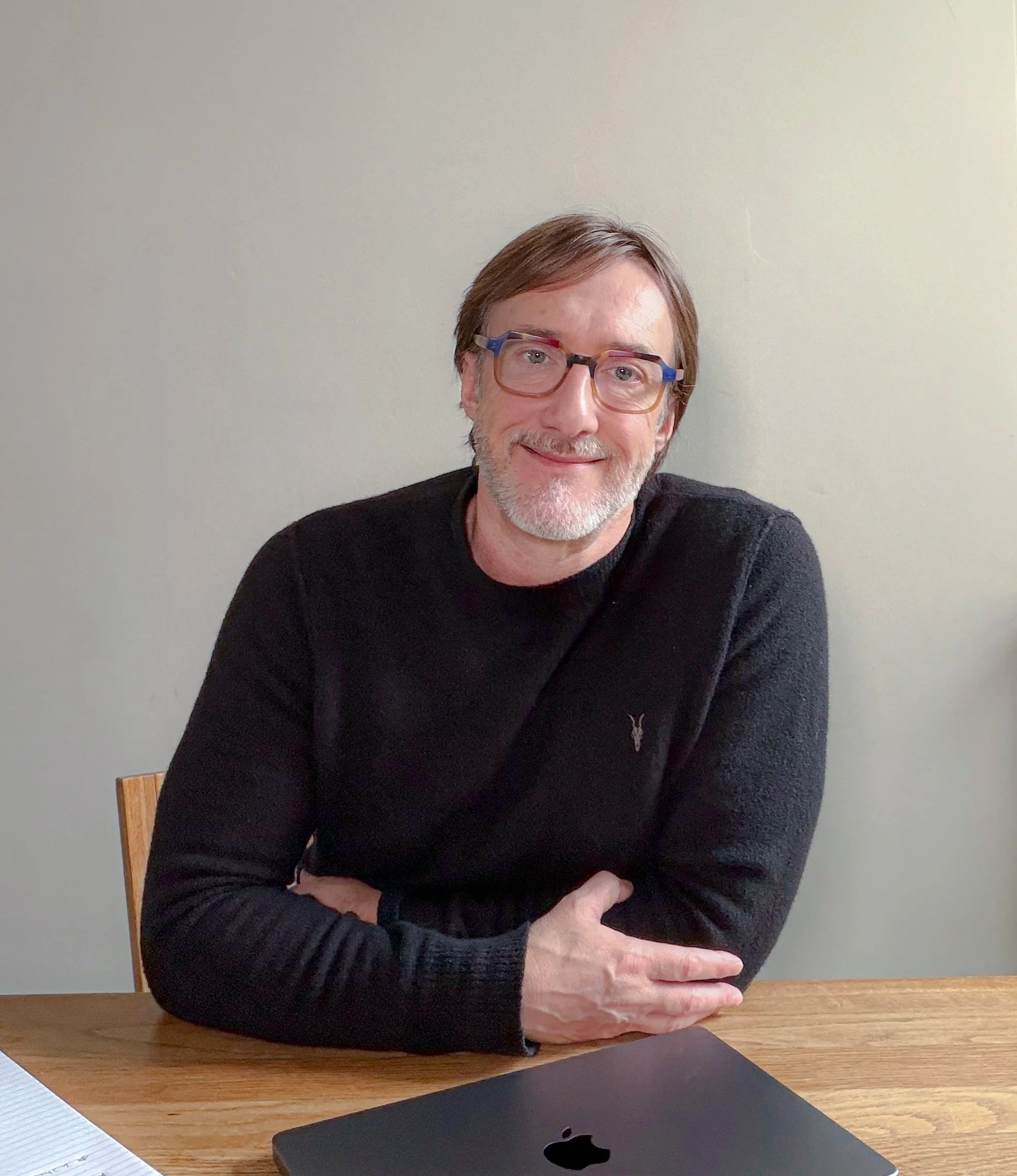 image of a man with black jumper and wearing glasses