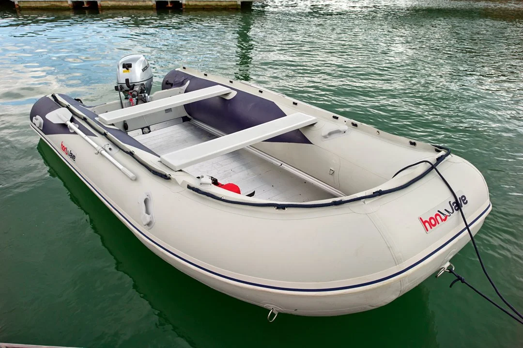 Inflatable boat with outboard motor floating on water