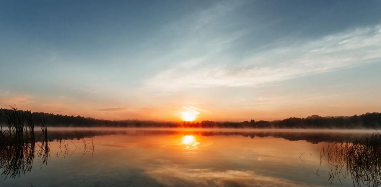 Sunrise over a calm lake symbolizing hope after darkness.