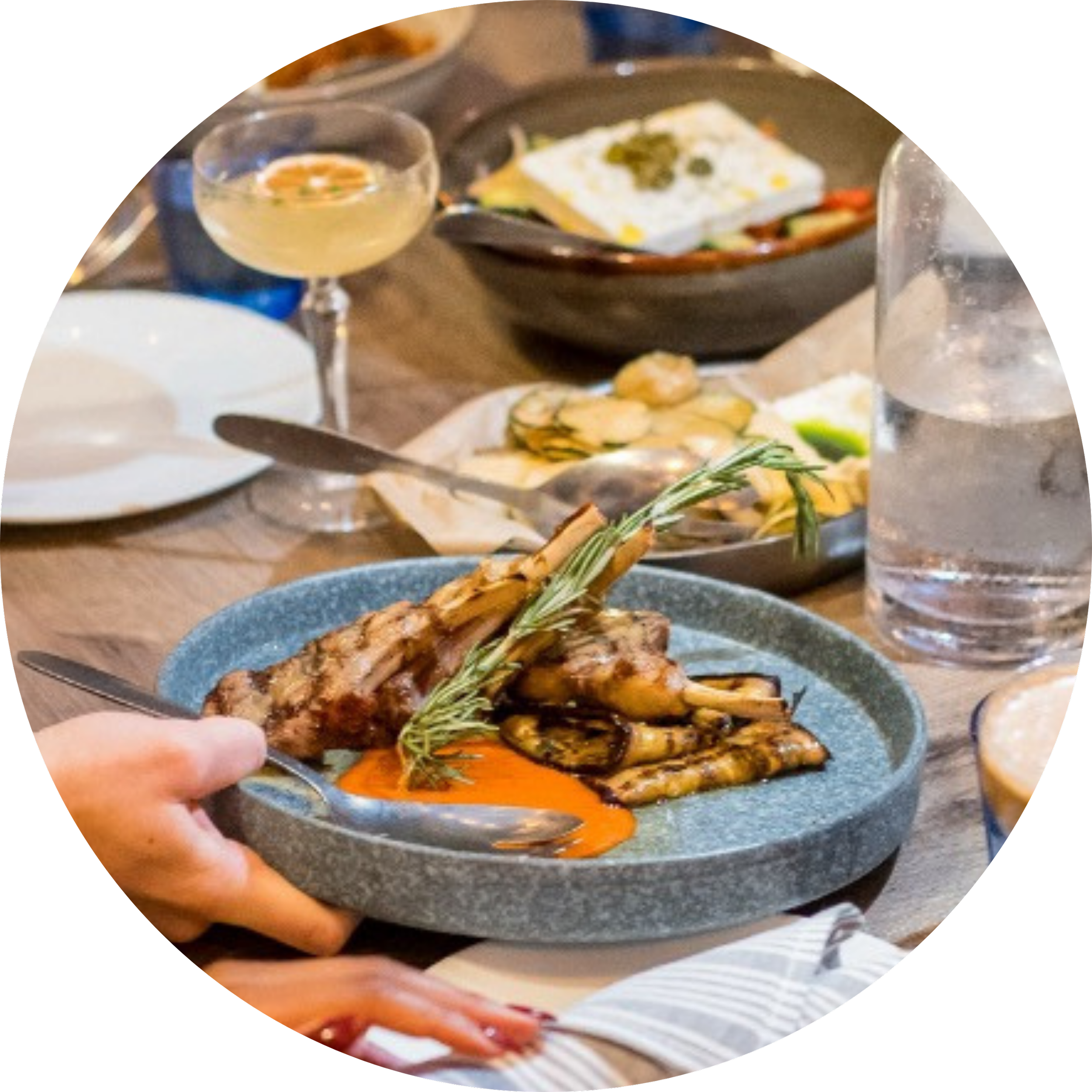 Assorted restaurant dishes being served at a dining table.