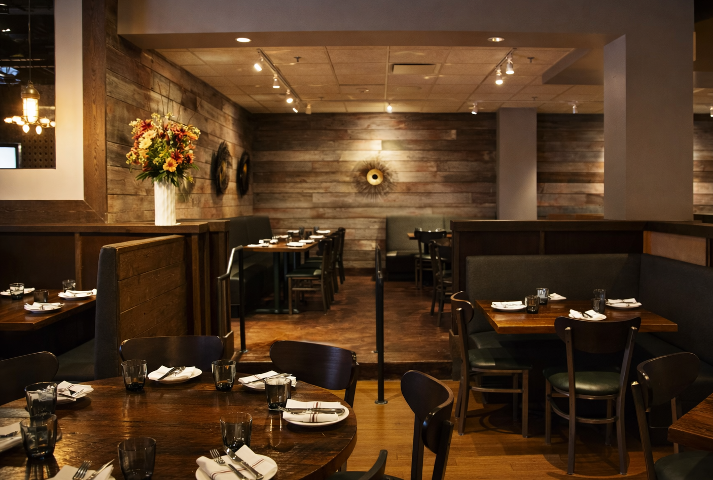 Warmly lit restaurant interior with tables and chairs.