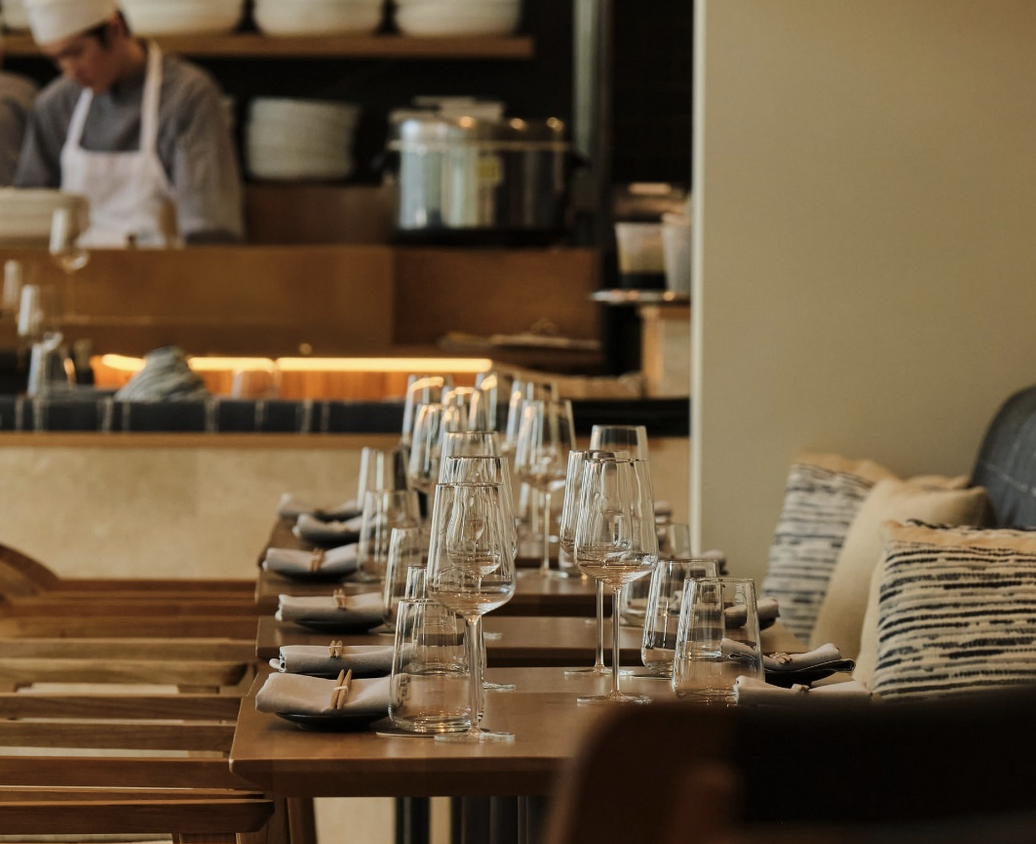 Modern restaurant dining room with tables set for service.