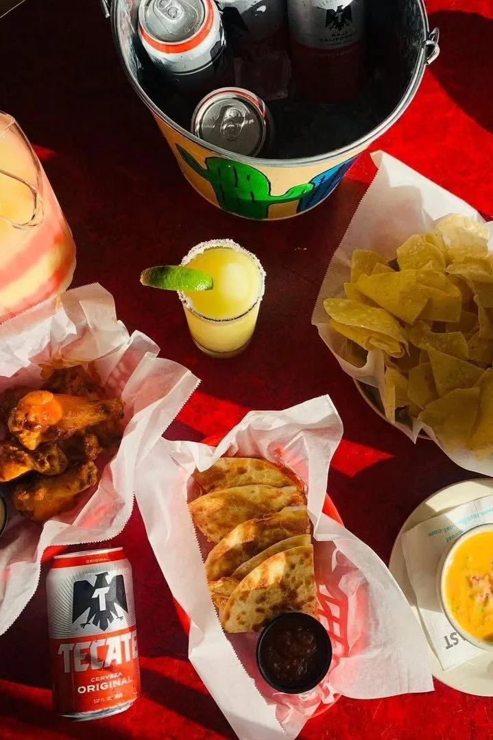 Casual meal with tacos, chips, and drinks on a red table.