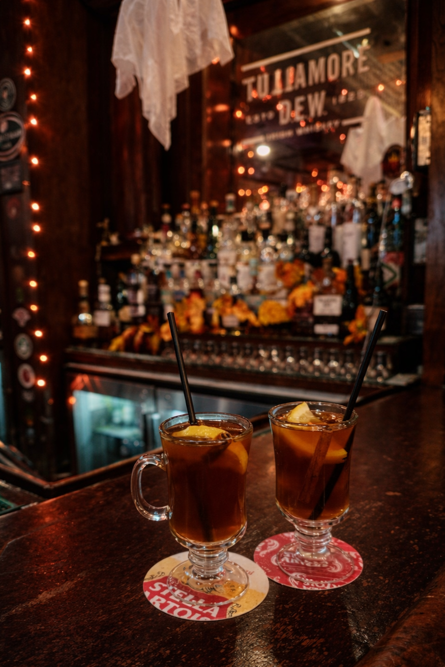 Dimly lit bar lined with bottles and cocktails.
