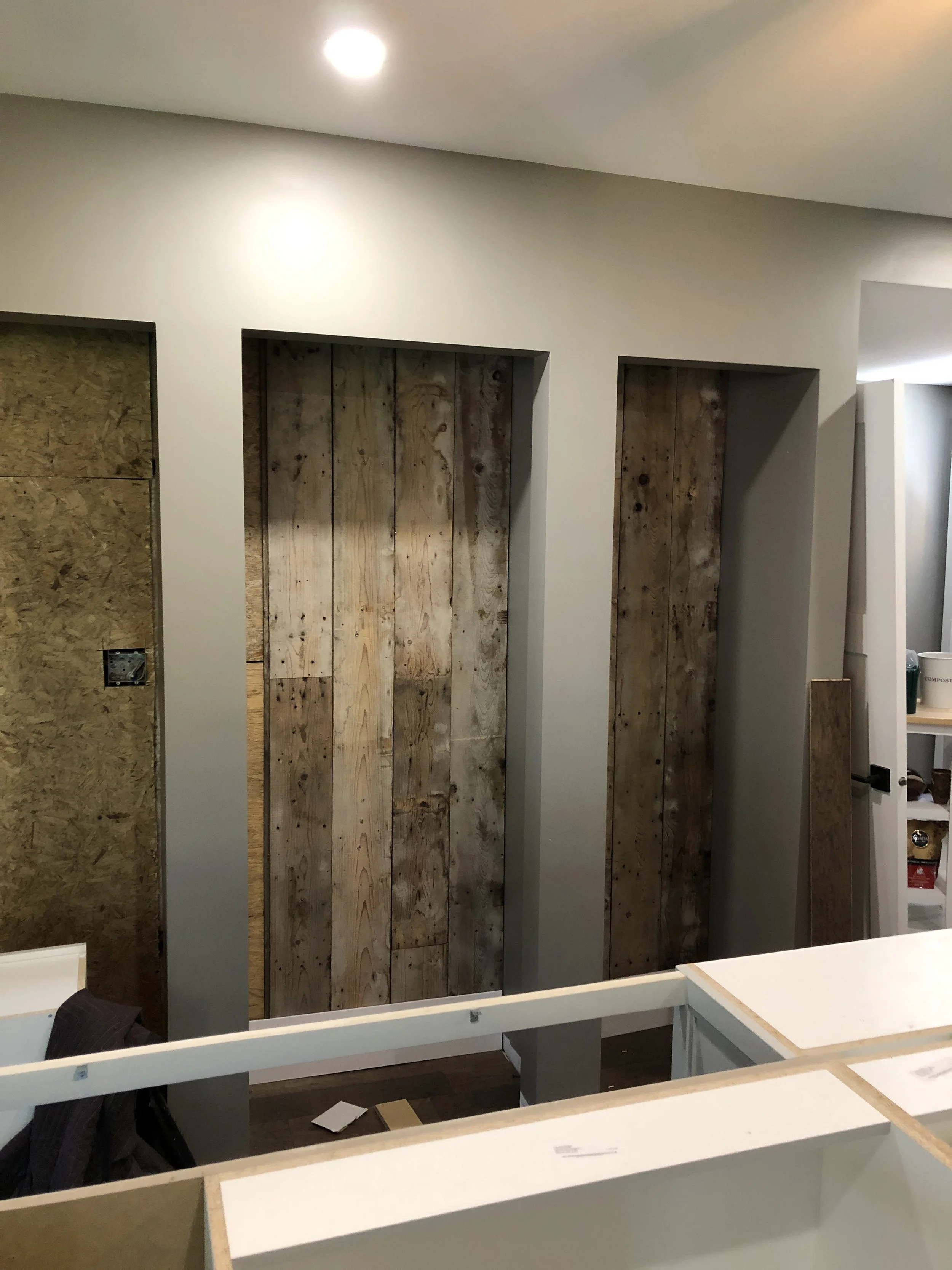 Creating the coffee station (left), pantry (centre), and wine bar (right) with repurposed original siding from the exterior walls of the home.