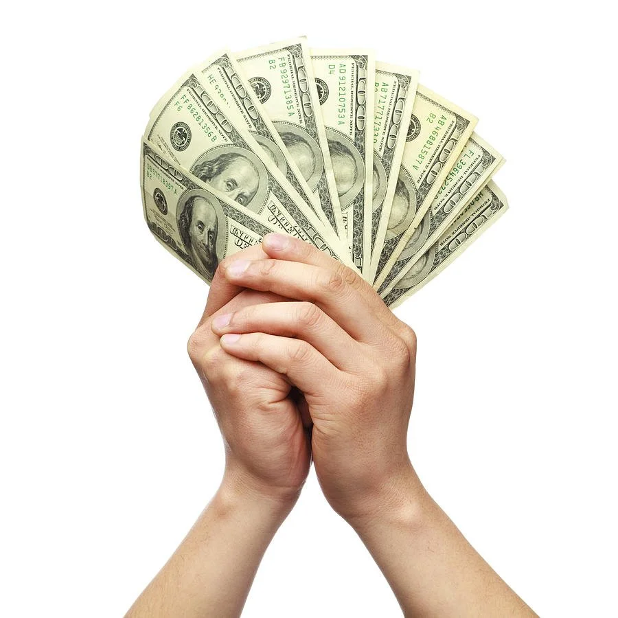 Hands hold up One Hundred Dollar Bills