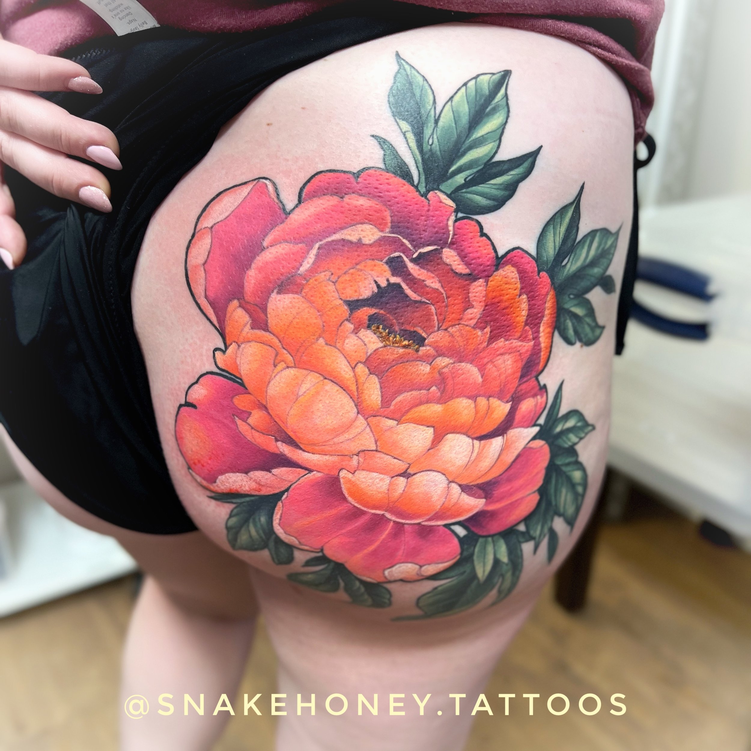 Large colorful flower tattoo on thigh